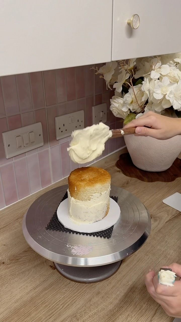 A mini cake being finished with buttercream